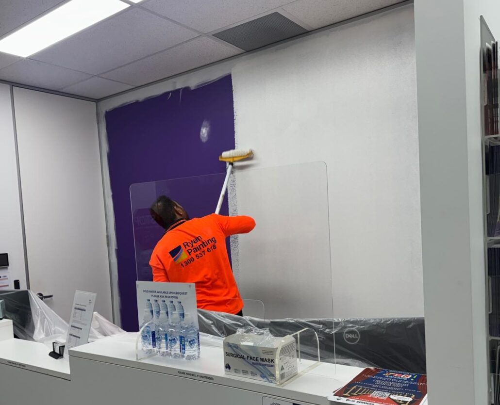 Painter completing an interior commercial repainting project in an office